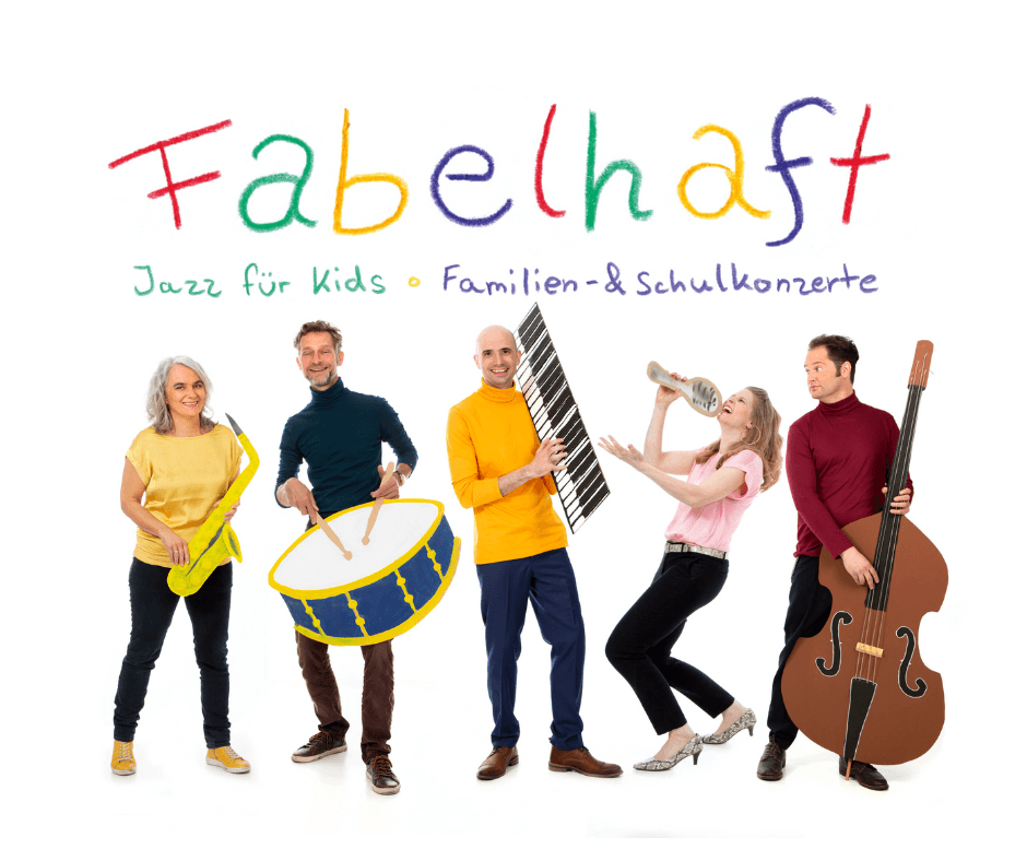 Fünf Personen posieren lächelnd mit bunten Instrumenten vor dem Schriftzug Fabelhaft.