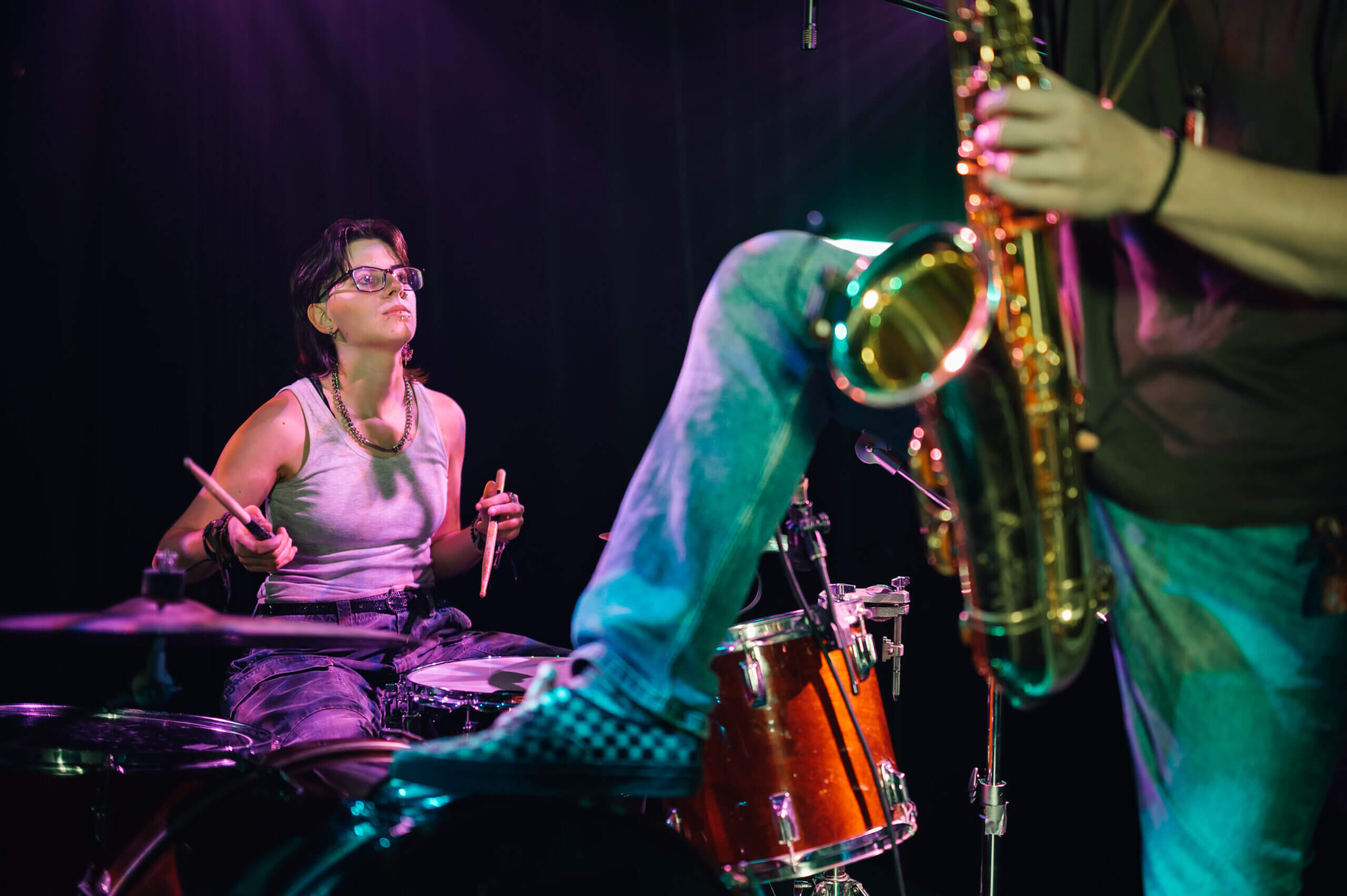 Schlagzeuger und Saxophonspieler auf einer Bühne.